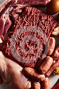 Carnivore diet or low carb diet background concept. Raw animal meat products beef, minced pork and sausages, chicken