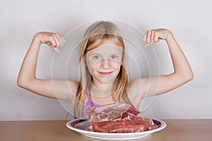 Carnivore keto diet concept - little blond girl eating raw meat