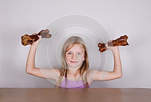 Carnivore keto diet concept - little blond girl eating raw meat