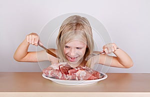 Carnivore keto diet concept - little blond girl eating raw meat