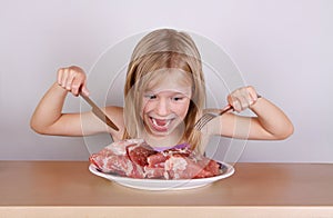 Carnivore keto diet concept - little blond girl eating raw meat