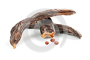 Carob carob fruit and seeds on white background. Isolate. Organic carob beans, a healthy alternative to cocoa photo