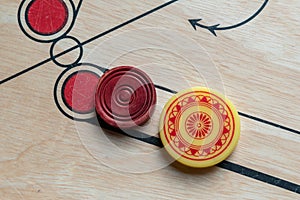 Carom striker and carom men on carom board.