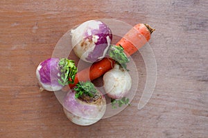 Carot and radishes on a woodbackground