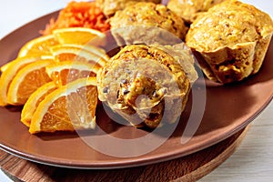 Carotte muffins served on the plate with orange slices photo