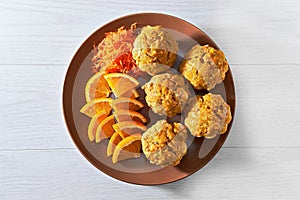 Carotte muffins served on the plate with orange slices, close up photo