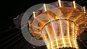 Carousel in an amusement park in slow motion at night. Holiday entertainment in the amusement park