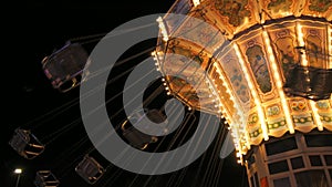 Carousel in an amusement park in slow motion at night. Holiday entertainment in the amusement park