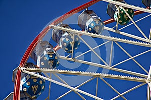 Carousel. Ferris Wheel on a blue background. Carriages of the big wheel