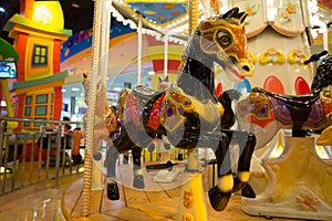 Carousel with horses in theme park.