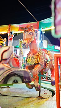 carousel ride and Ferris wheel at night amusement park Thai style festival.