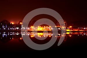 Carousels wheel and city and reflection at night in city