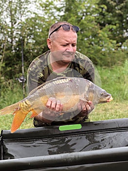 Carp fishing. Fisherman showing his catch, carp