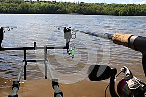 Carp fishing indicator. Warning for fishing, detailed swinger. Carp fishing on the dam. Fishing rod on a rod pod.