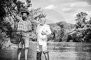 Carp fishing. retired dad and mature bearded son. Two male friends fishing together. Catching and fishing concept. fly