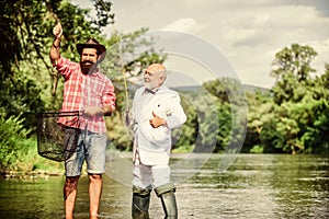 carp fishing. retired dad and mature bearded son. Two male friends fishing together. Catching and fishing concept. fly