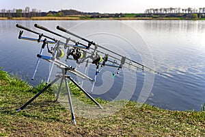 Carp fishing rods standing on rod pod near the lake during sunrise. Morning fishing on the lake