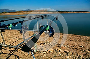 Carp fishing. Two angling scene. Looking along three carp rods towards a pond.