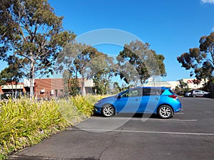 Carpark with blue vehicle during sunlight afternoon