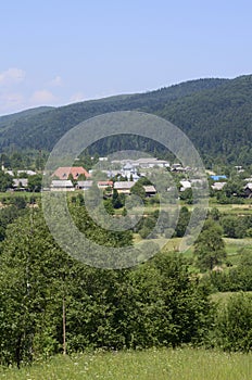 Carpathian village: country houses, gardens, forest and mountains