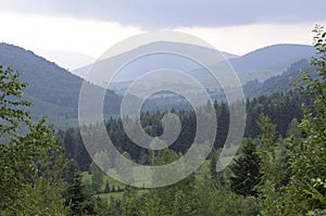 Carpathians: valley, forest, mountains, clody sky. Lugi village Ukraine