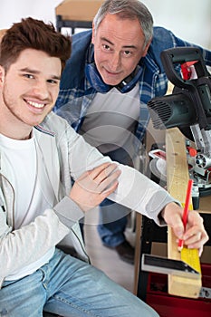 Carpenter and apprentice inspecting measurements