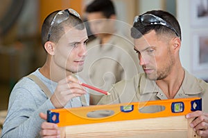 carpenter and apprentice installing luxury fitted kitchen