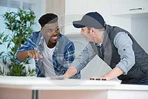 carpenter and apprentice installing luxury fitted kitchen