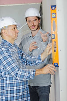 Carpenter and apprentice installing luxury fitted kitchen