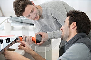 carpenter and apprentice installing luxury fitted kitchen