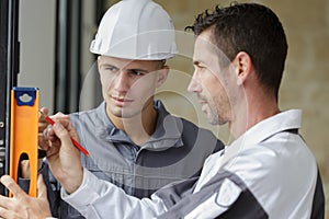 carpenter and apprentice installing luxury fitted kitchen