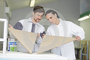 carpenter and apprentice working together in wood workshop