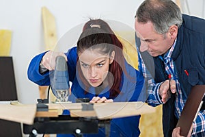 carpenter and apprentice working together in workshop