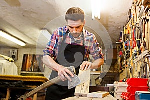 Carpenter with ax and board working at workshop