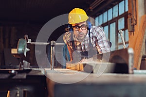 Carpenter blows wood chips from the tree when planning