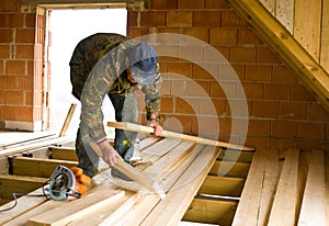 Carpenter building new floor of a loft room photo