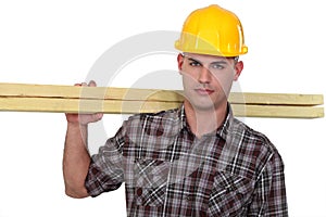 Carpenter carrying planks