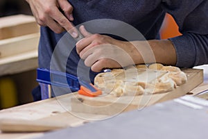 Carpenter with a chisel in his hands on the workbench