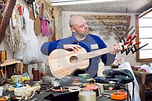 Carpenter creating guitar in workshop