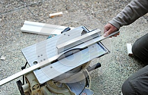 Carpenter by cutting with a disc saw a profile of white wood