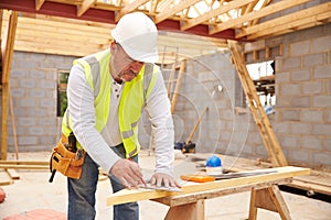 Carpenter Cutting House Roof Supports On Building Site