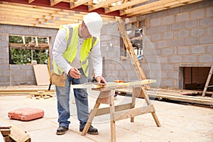 Carpenter Cutting House Roof Supports On Building Site