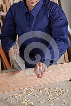 Carpenter cutting a piece of wood