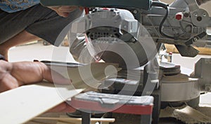 Carpenter cutting a plank with circular saw