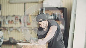 Carpenter Cutting Wood With Handsaw In Workshop