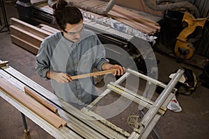 Carpenter cutting wooden plank