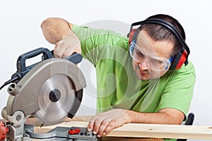 Carpenter cutting wooden plank