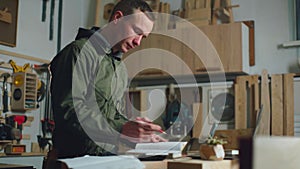 A carpenter designs furniture. Man Owner of a carpentry shop. Carpenter working.