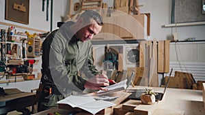 Carpenter designs products in a joinery. Small business owner, carpenter works.