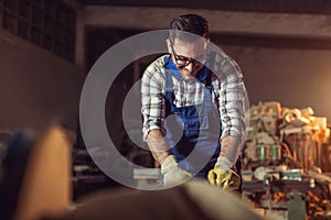 Carpenter doing his job in carpentry workshop